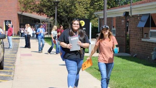 A group of people walking on a sidewalk